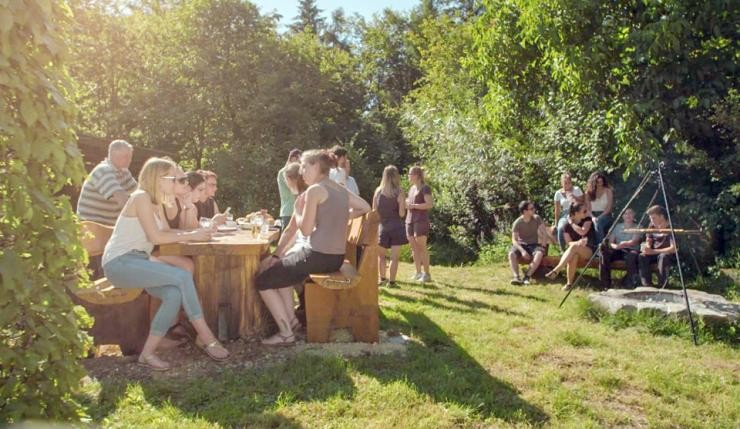 Auszubildende des Landratsamtes sitzen an einem Tisch im Freien beim Grillenpingen im Freien