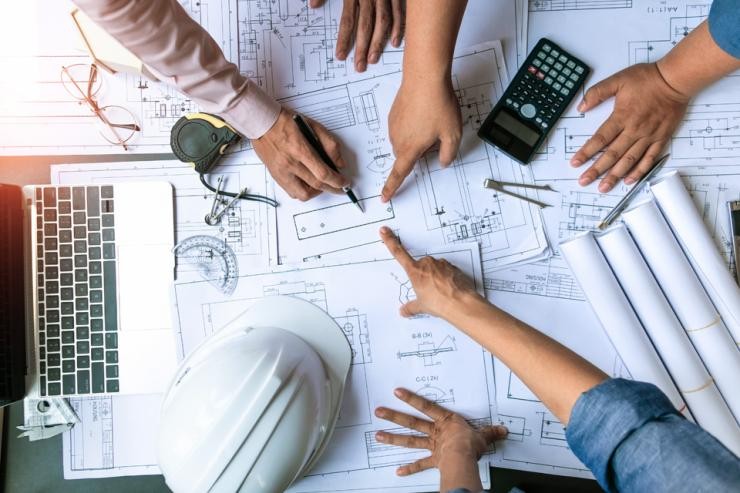 Bauingenieurswesen Öffenltiches Bauen Landkreis Göppingen Mehrere Personen zeigen mit ihren Fingern auf einen Bauplan im Rahmen einer Besprechung
