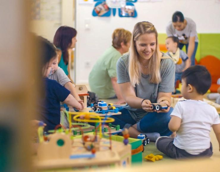 Soziale Arbeit in der Elementarpädagogik Studierende spielt mit Kindern im Familientreff