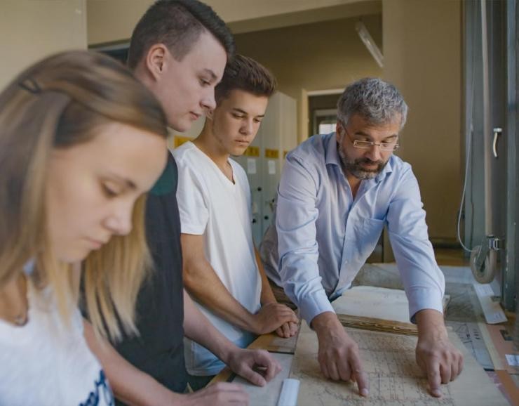 Fachangestellte*r für Medien- und Informationsdienste – Archiv Azubis Medien- und Informationsdienste mit Lehrer an alten Dokumenten